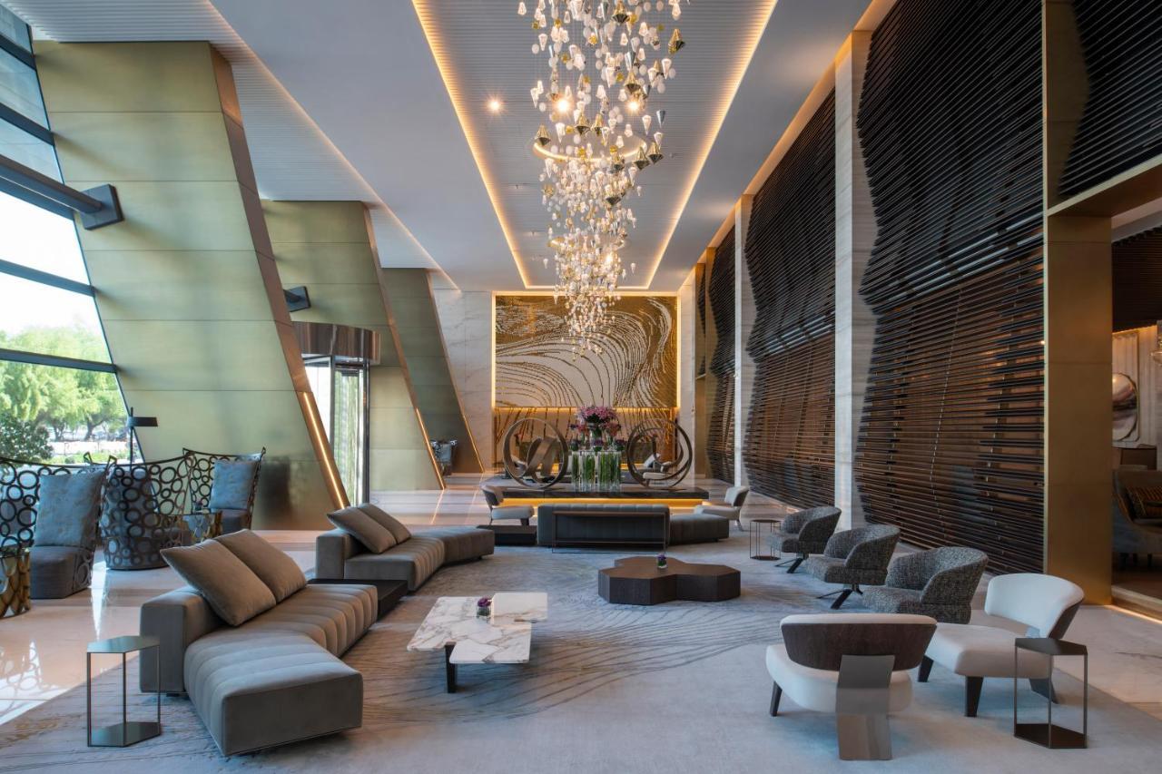 Steigenberger Hotel Doha Exteriör bild The photo depicts a modern and stylish hotel lobby. It features a spacious interior with elegant design elements. Prominent highlights include:

- A large, artistic chandelier hanging from the ceiling, providing ambient lighting.
- A central seating 